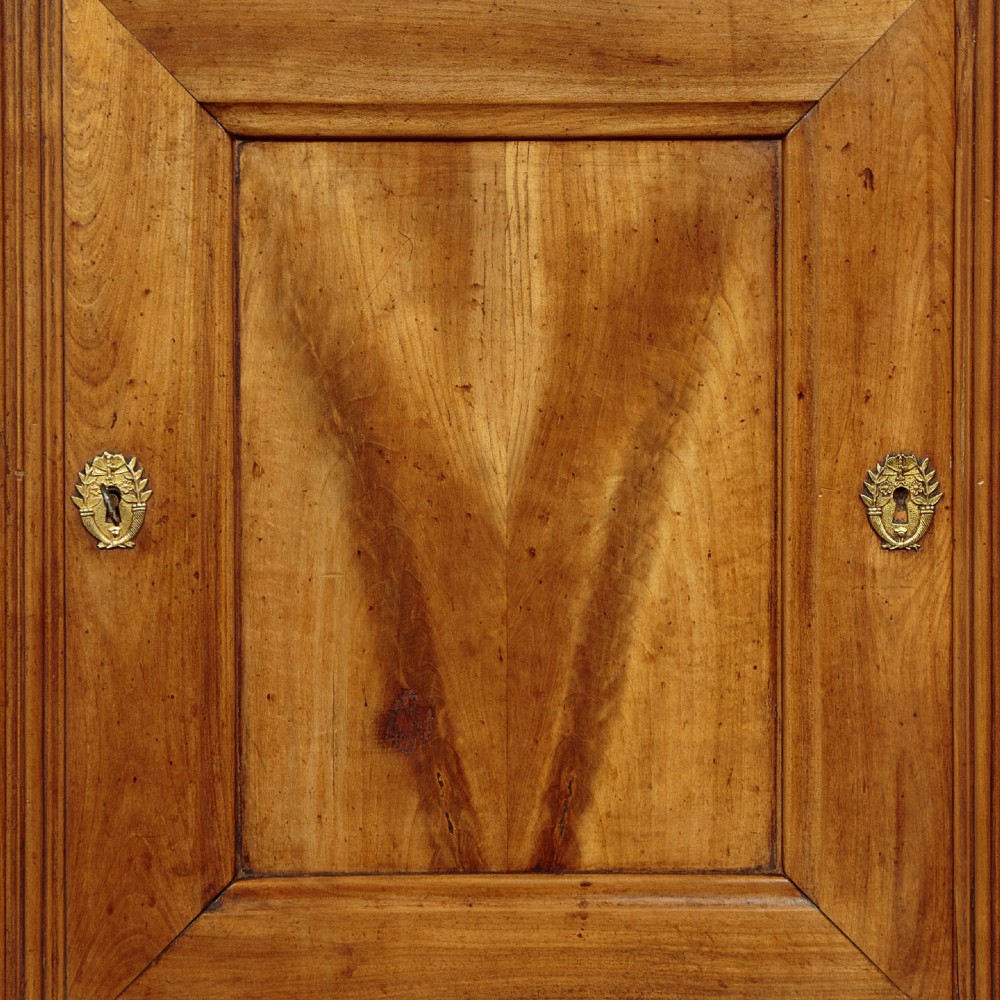 A 19th-century French cherrywood enfilade featuring three drawers over three panelled doors with geometric wood grain and brass escutcheons. View VIII