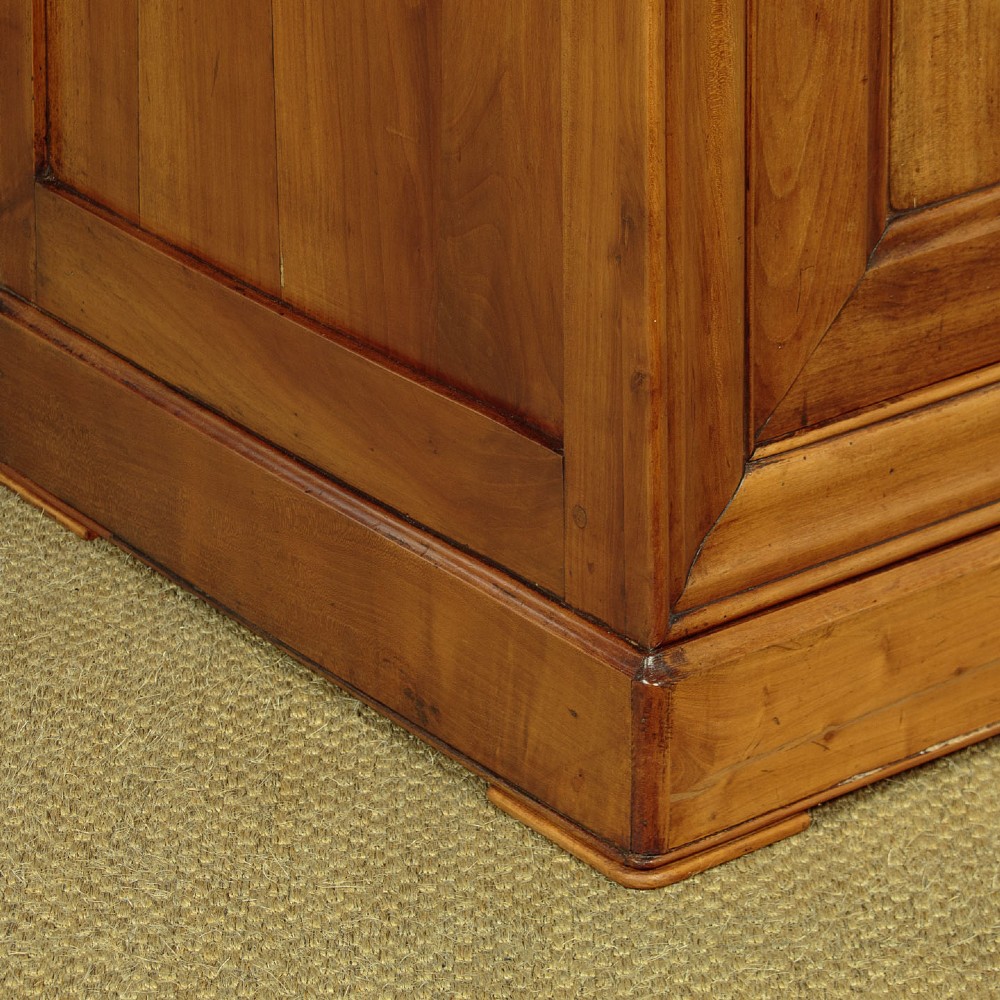 A 19th-century French cherrywood enfilade featuring three drawers over three panelled doors with geometric wood grain and brass escutcheons. View X