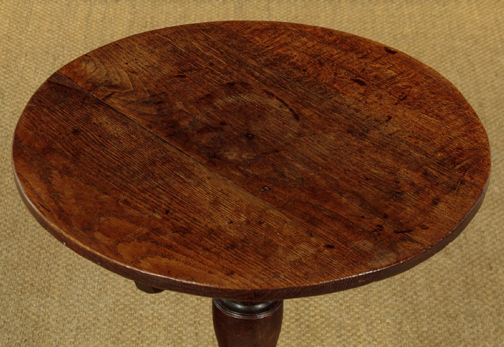 An 18th-century dark oak tripod table featuring a circular top, a central turned column, and three splayed legs. View IV
