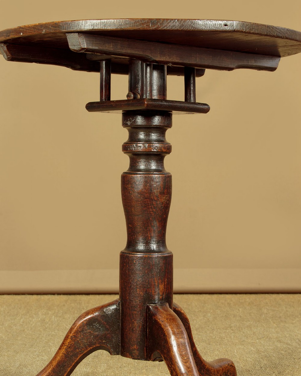 An 18th-century dark oak tripod table featuring a circular top, a central turned column, and three splayed legs. View VI