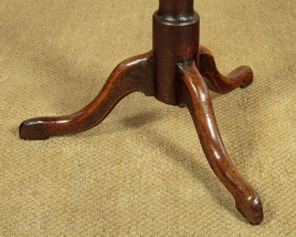 An 18th-century dark oak tripod table featuring a circular top, a central turned column, and three splayed legs. View VII