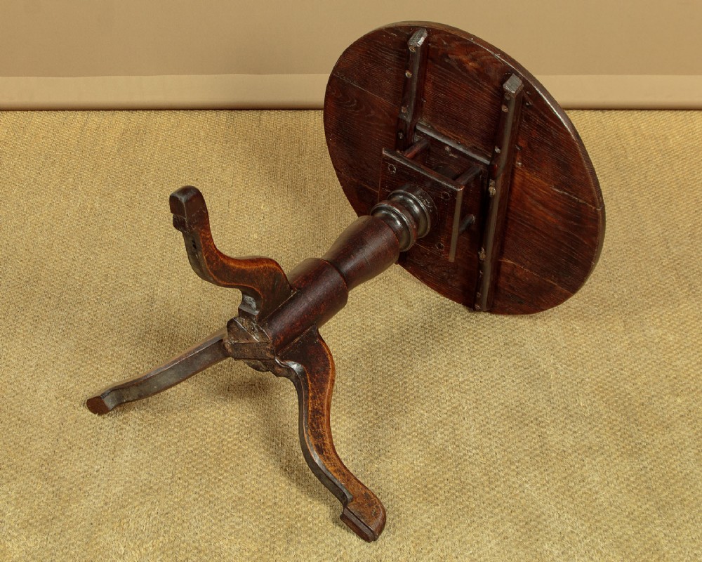 An 18th-century dark oak tripod table featuring a circular top, a central turned column, and three splayed legs. View IX