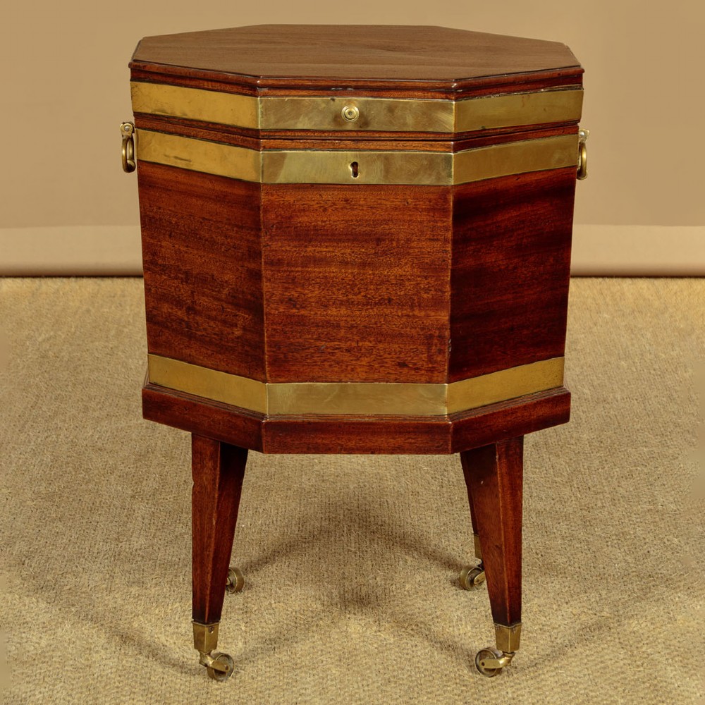 An octagonal Georgian mahogany cellarette bound in brass bands on tapered legs with castors.