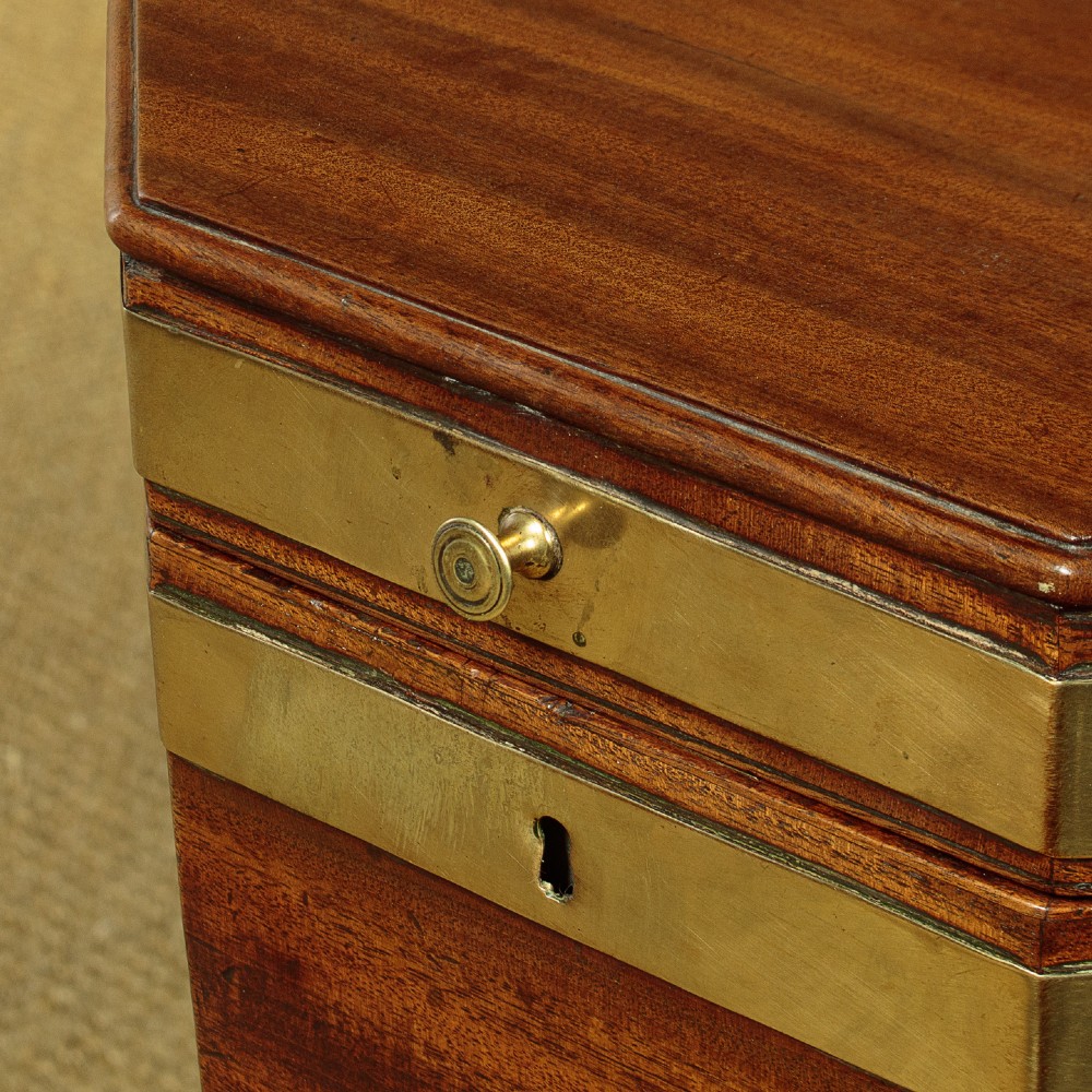 An octagonal Georgian mahogany cellarette bound in brass bands on tapered legs with castors. View V