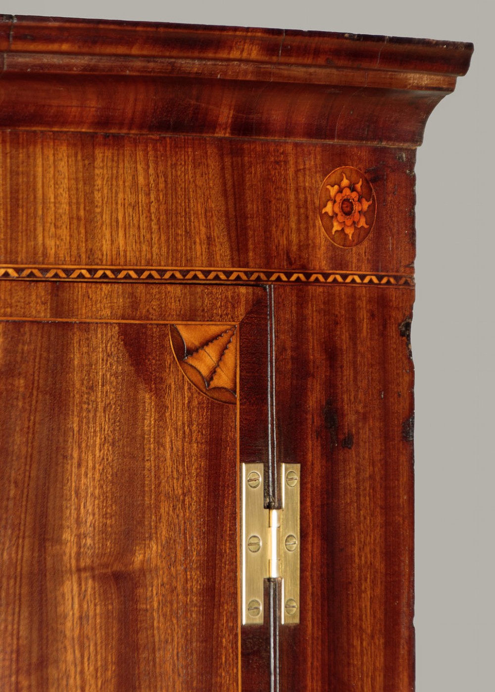 A George III bow-front mahogany corner cupboard featuring twin doors with inlaid fan motifs, crossbanded borders, and brass H-hinges. View IV