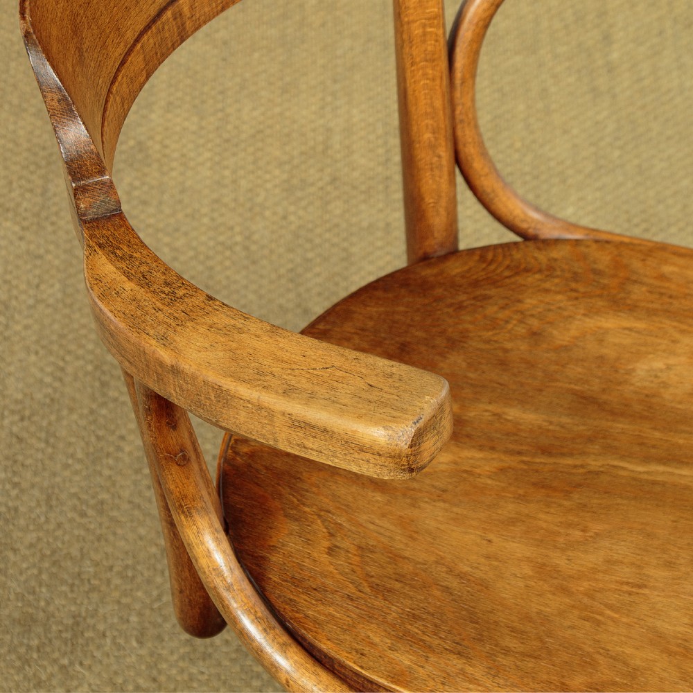 A pair of antique warm brown bentwood swivel desk chairs with curved armrests and quadruped pedestal bases. View VI