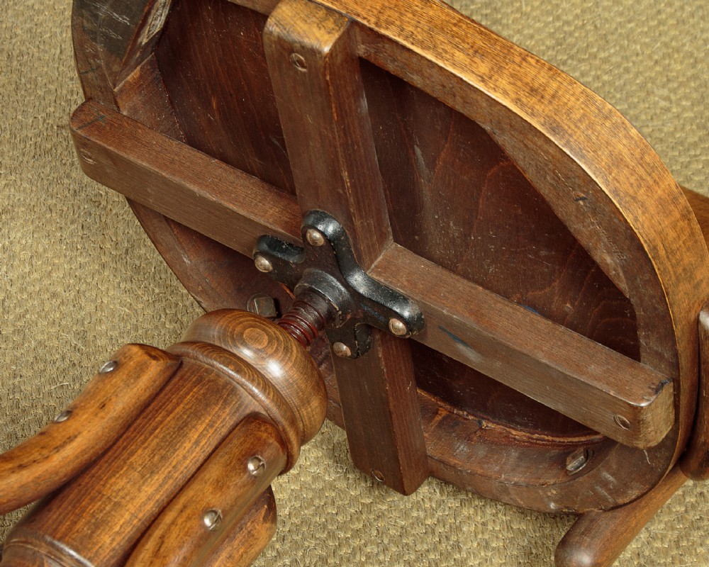 A pair of antique warm brown bentwood swivel desk chairs with curved armrests and quadruped pedestal bases. View IX