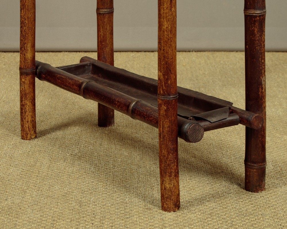 Late Victorian dark bamboo hall stand featuring a central diamond mirror, a hand-painted floral lacquer panel, coat pegs, and a stick stand base. View XI