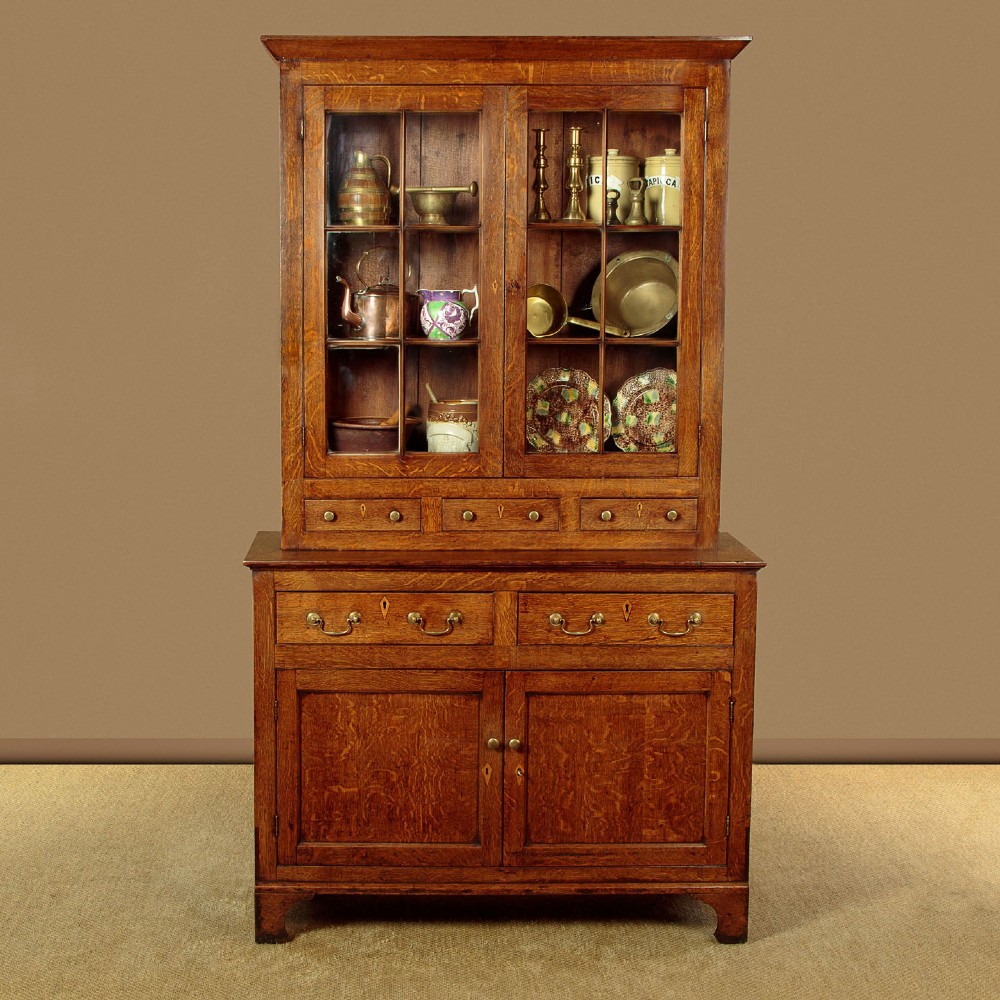A Georgian Welsh oak cwpwrdd gwydr featuring a glazed upper section with two six-pane glass doors above three small drawers, resting on a base cabinet with two drawers over a panelled double cupboard. View II