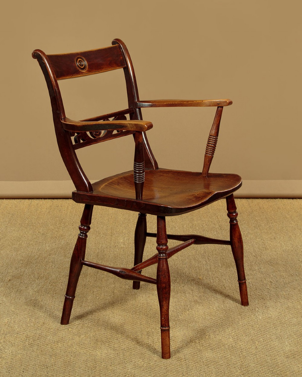 A Victorian Oxford bar back Windsor armchair made from dark timber with turned legs, a carved middle back rail, and a contoured saddle seat. View III