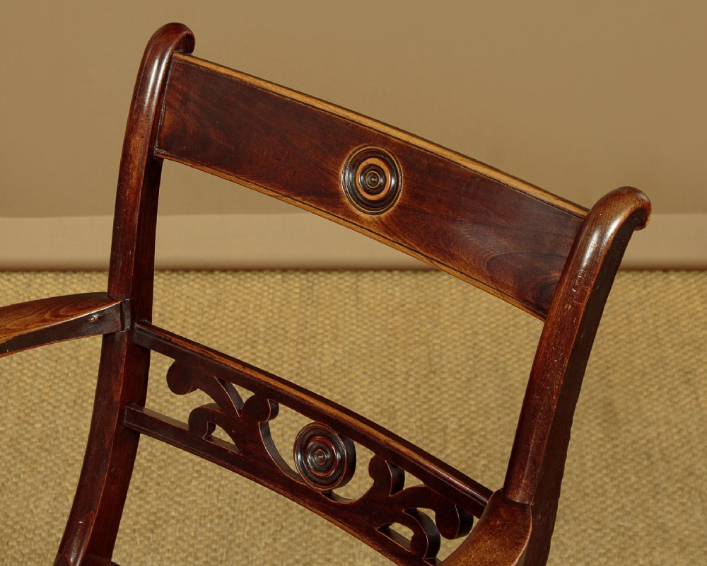 A Victorian Oxford bar back Windsor armchair made from dark timber with turned legs, a carved middle back rail, and a contoured saddle seat. View IV