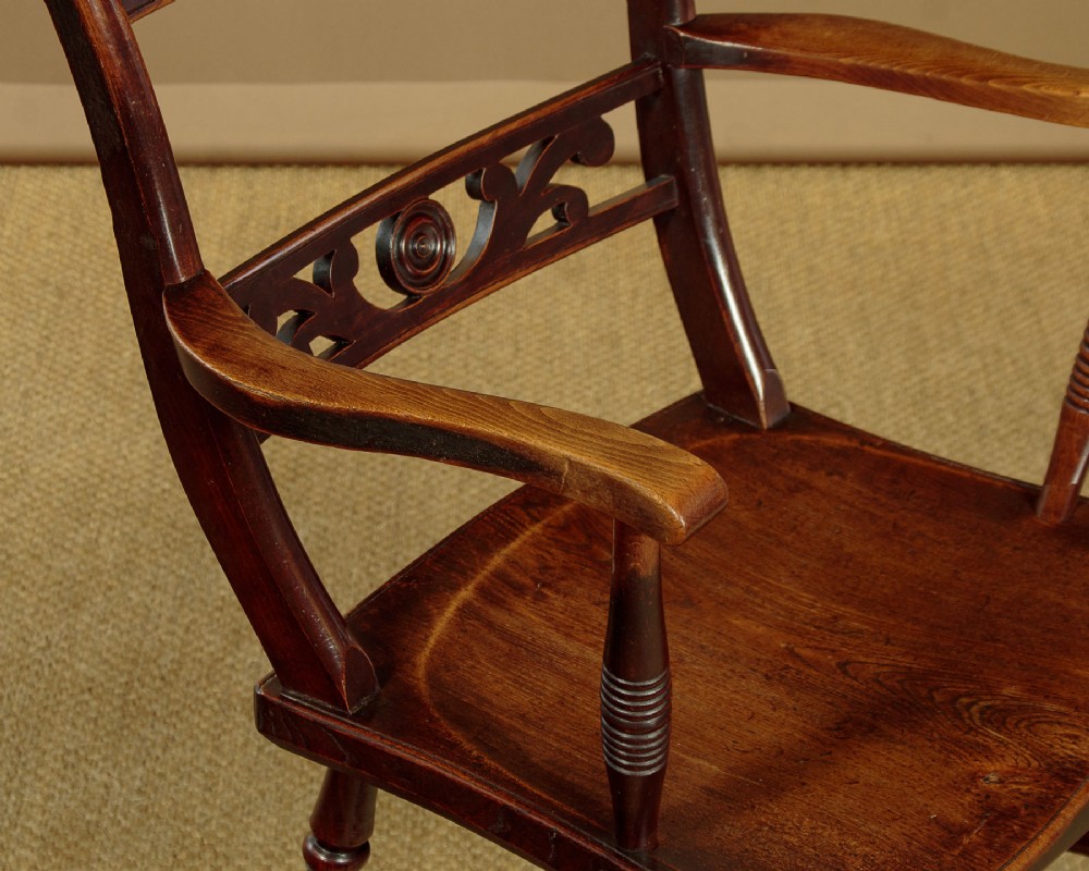 A Victorian Oxford bar back Windsor armchair made from dark timber with turned legs, a carved middle back rail, and a contoured saddle seat. View VII