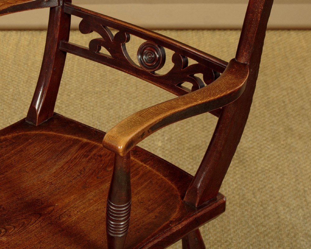 A Victorian Oxford bar back Windsor armchair made from dark timber with turned legs, a carved middle back rail, and a contoured saddle seat. View VIII
