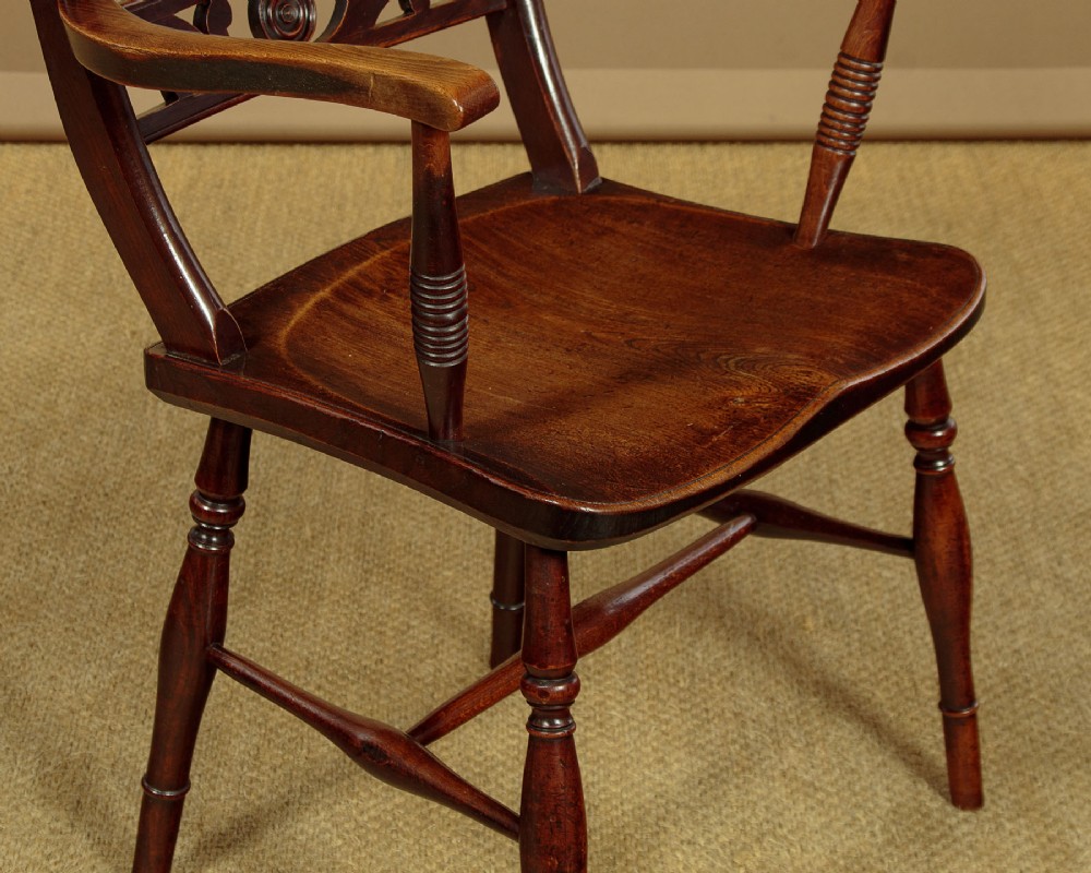 A Victorian Oxford bar back Windsor armchair made from dark timber with turned legs, a carved middle back rail, and a contoured saddle seat. View IX