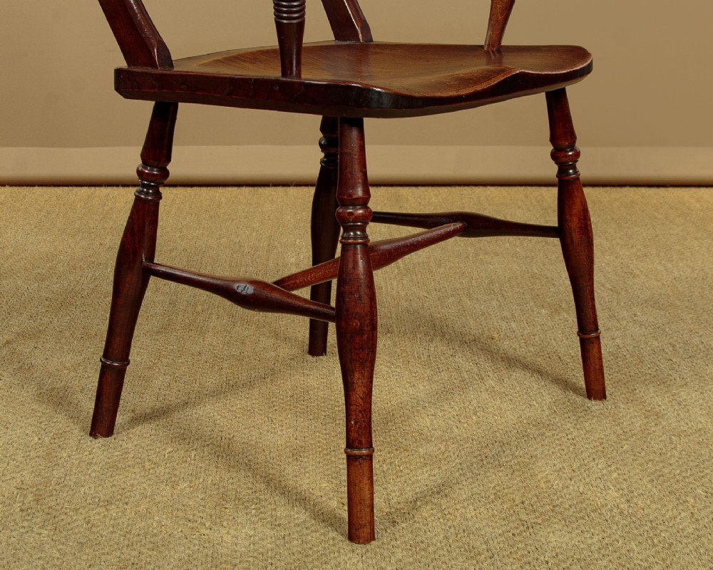 A Victorian Oxford bar back Windsor armchair made from dark timber with turned legs, a carved middle back rail, and a contoured saddle seat. View XII