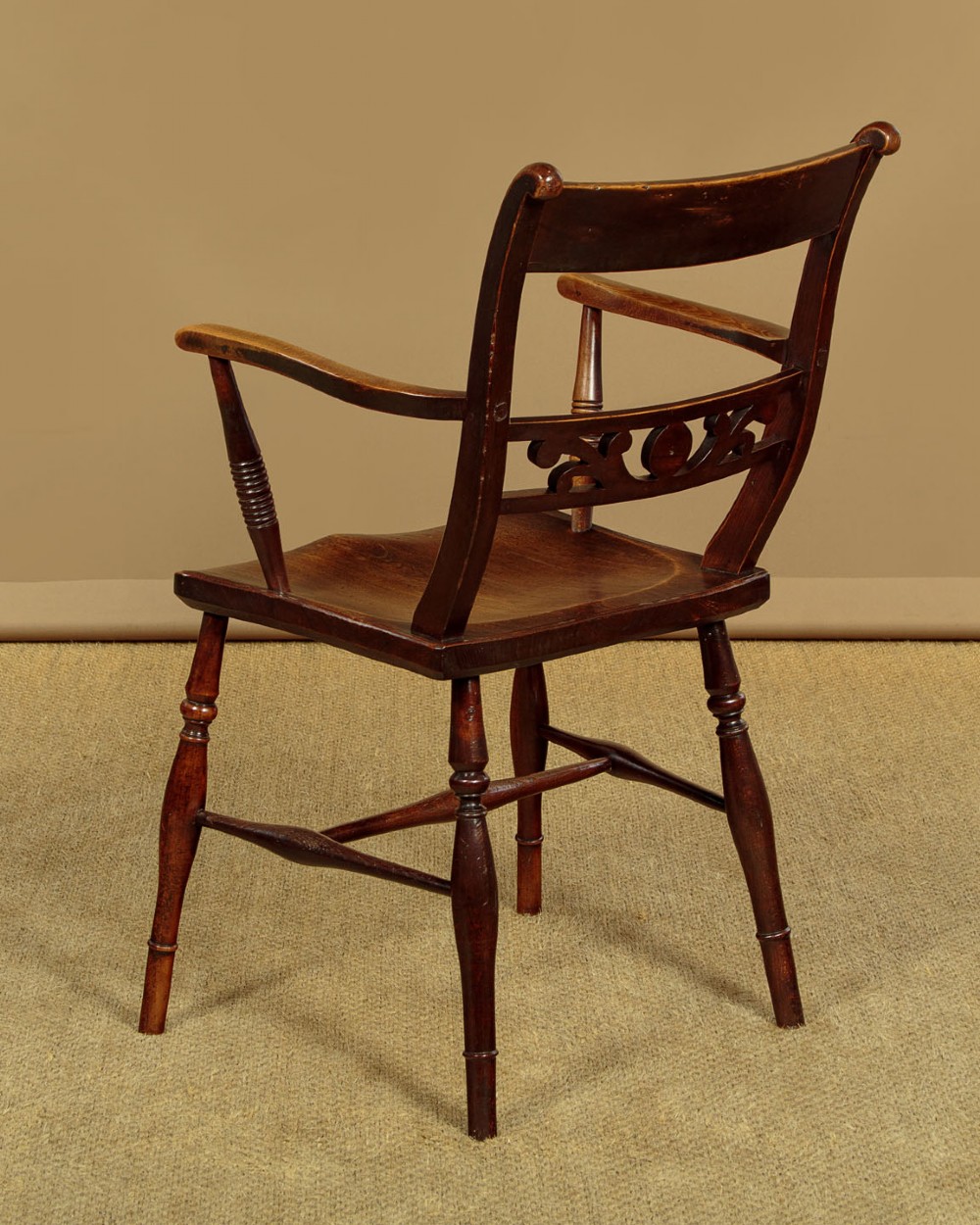 A Victorian Oxford bar back Windsor armchair made from dark timber with turned legs, a carved middle back rail, and a contoured saddle seat. View XIV