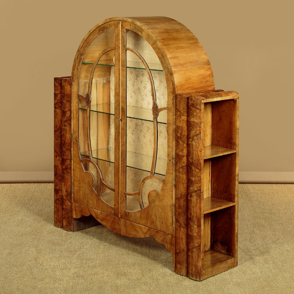 An Art Deco walnut display cabinet featuring a domed central section with two glazed doors and curved glazing bars, flanked by open side shelves. View III