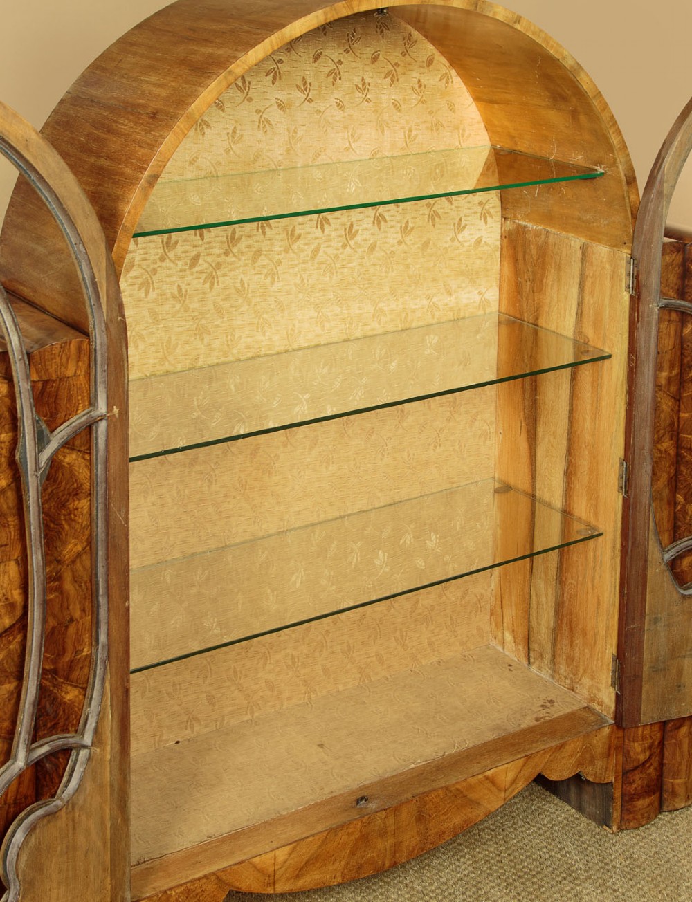 An Art Deco walnut display cabinet featuring a domed central section with two glazed doors and curved glazing bars, flanked by open side shelves. View IV