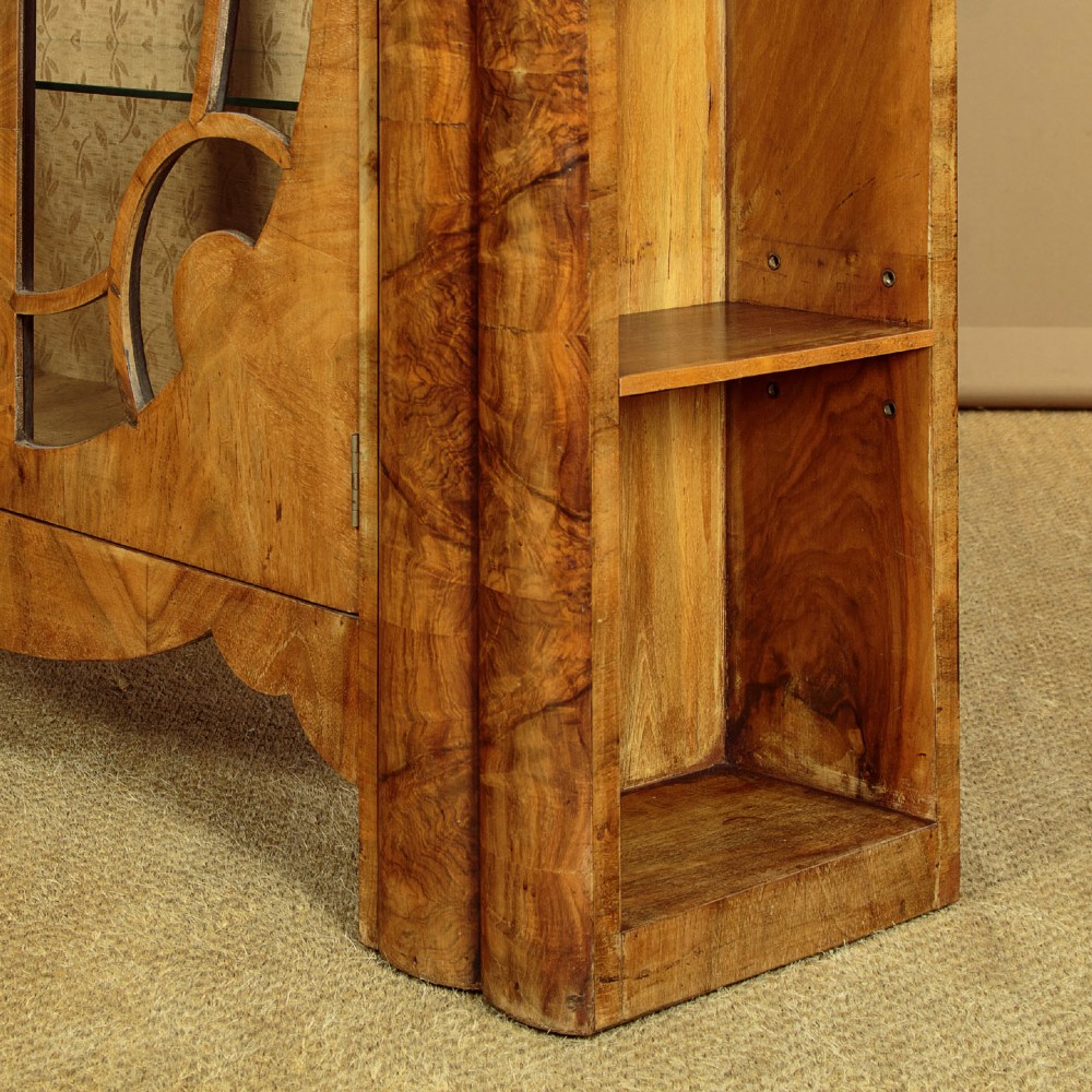 An Art Deco walnut display cabinet featuring a domed central section with two glazed doors and curved glazing bars, flanked by open side shelves. View IX