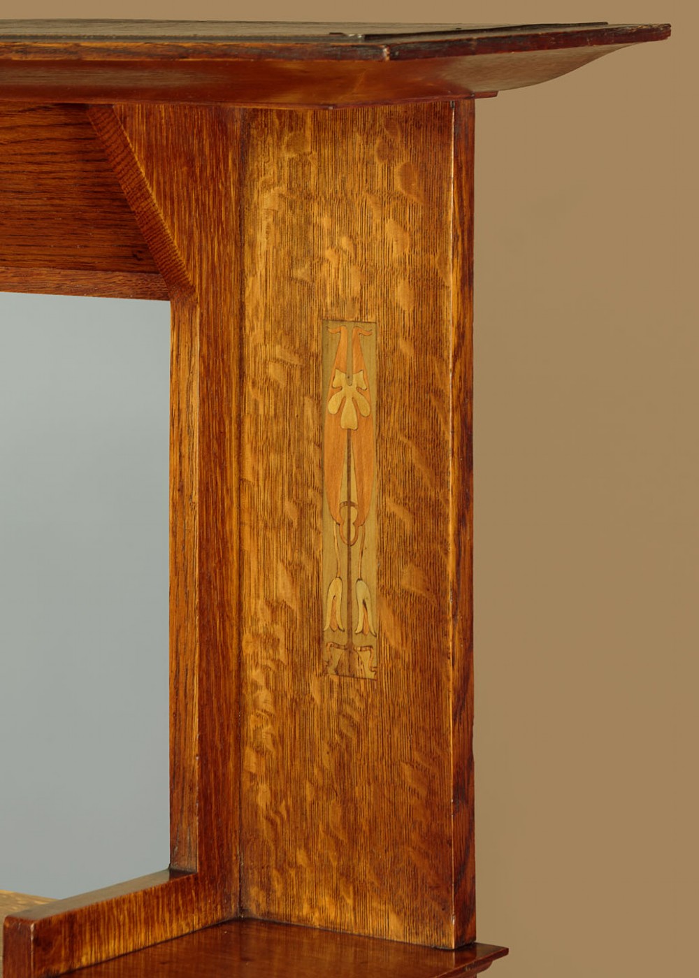 An Arts and Crafts quarter-sawn oak dresser featuring a mirrored top structure with small display shelves, inlaid floral details, hammered copper strap hinges, two drawers, and a lower cupboard. View VII