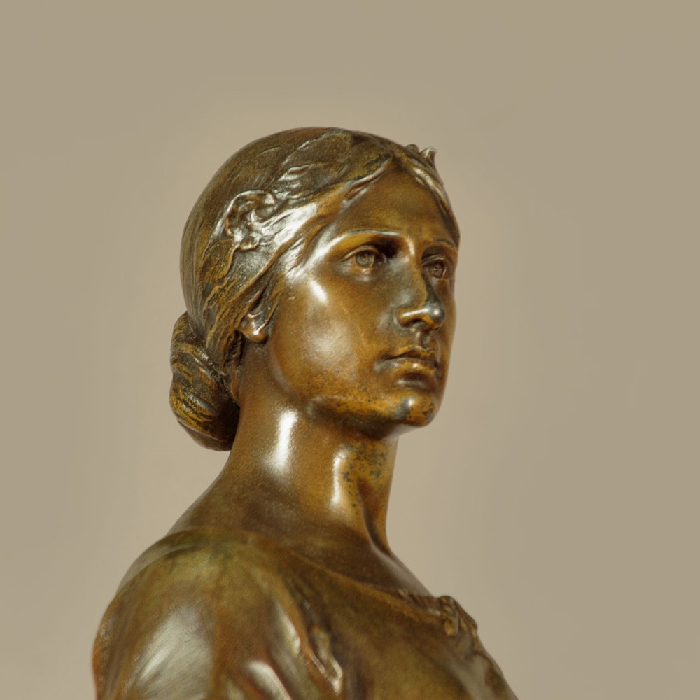 A patinated spelter statue of a standing female figure titled Dignite holding a sword and foliage branch, mounted on an integral square base. View VII