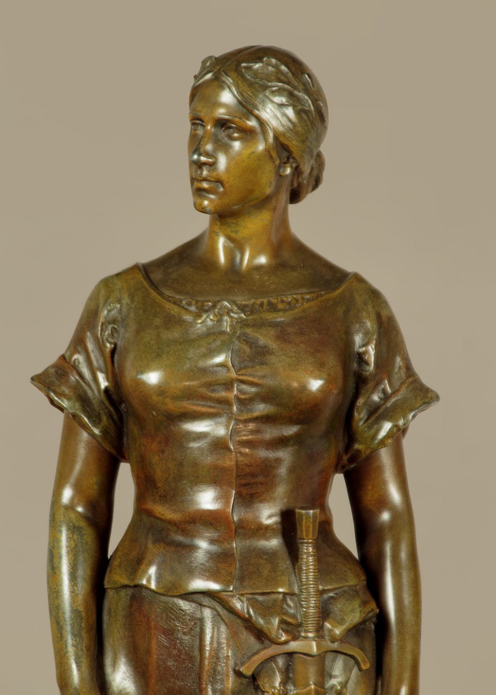 A patinated spelter statue of a standing female figure titled Dignite holding a sword and foliage branch, mounted on an integral square base. View IX