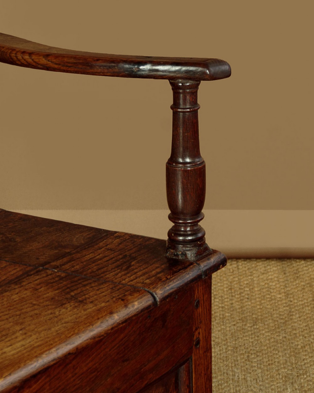 A dark oak box settle featuring a three-panel back with subtle arched top mouldings, curved armrests on turned supports, and a hinged seat opening to storage. View X