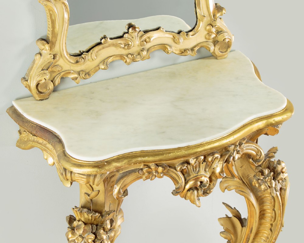 A small Rococo Revival gilded console table with a marble top, paired with an ornate matching carved wall mirror. View V