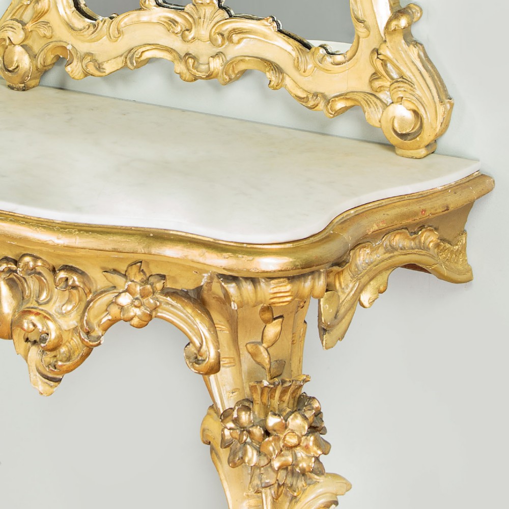 A small Rococo Revival gilded console table with a marble top, paired with an ornate matching carved wall mirror. View VI