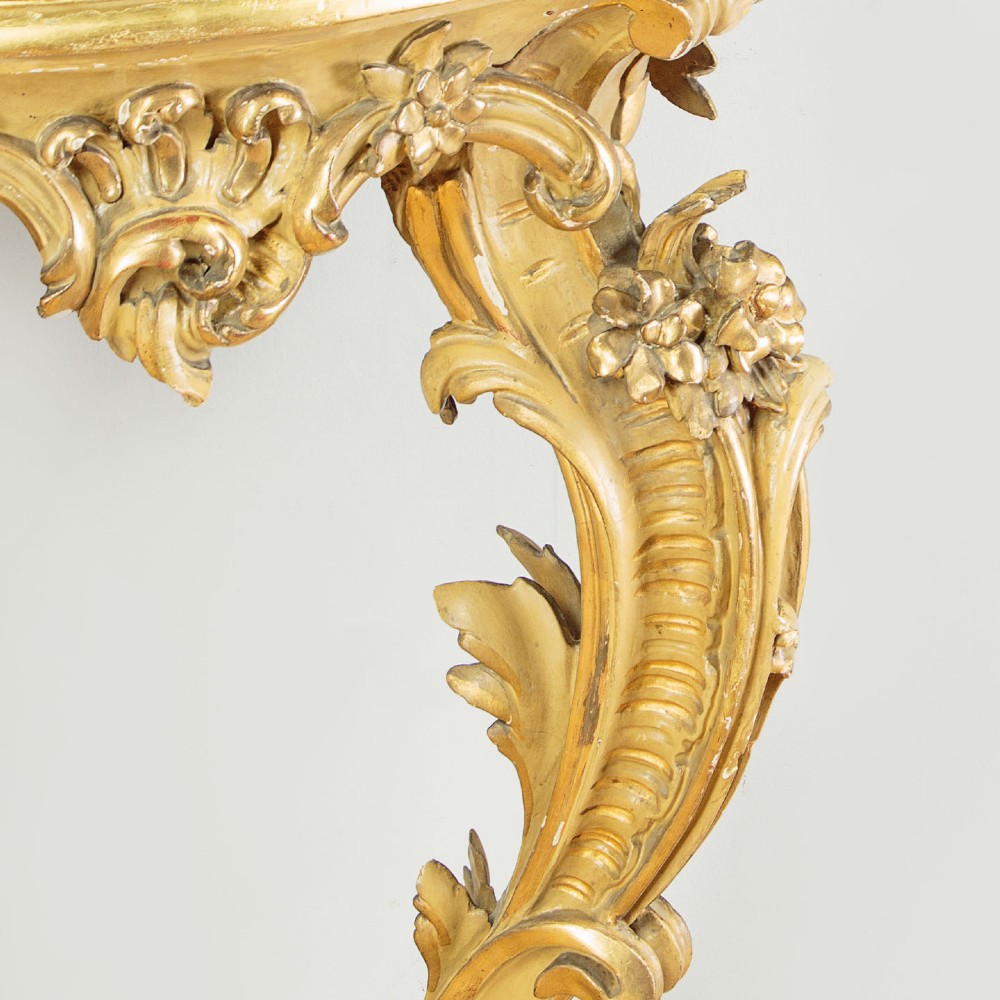 A small Rococo Revival gilded console table with a marble top, paired with an ornate matching carved wall mirror. View IX