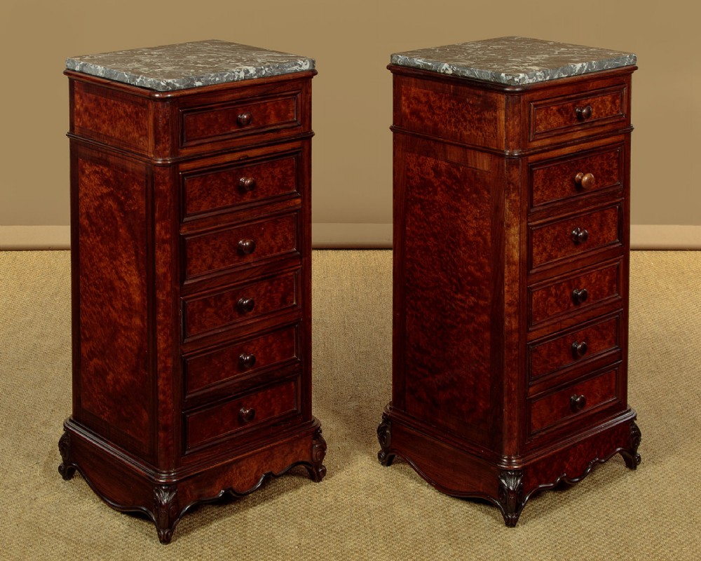 A pair of late Victorian dark rosewood and amboyna veneer tall bedside drawer pedestals featuring grey marble tops and turned wooden knobs. View II