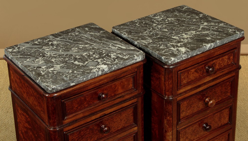 A pair of late Victorian dark rosewood and amboyna veneer tall bedside drawer pedestals featuring grey marble tops and turned wooden knobs. View IV