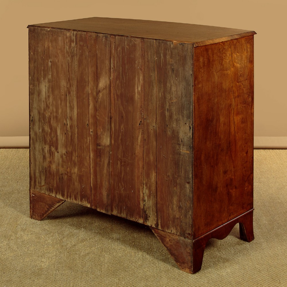 A Regency bowfront mahogany chest of drawers featuring two short and three long drawers with turned wooden knobs and a curved lower apron on splayed feet. View XIII