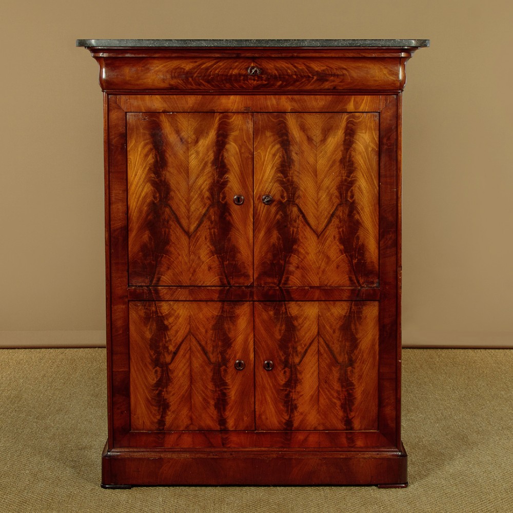A 19th-century French Louis Philippe flame mahogany cabinet featuring a dark marble top, a frieze drawer, and four symmetrical veneered cupboard doors over a plinth base.