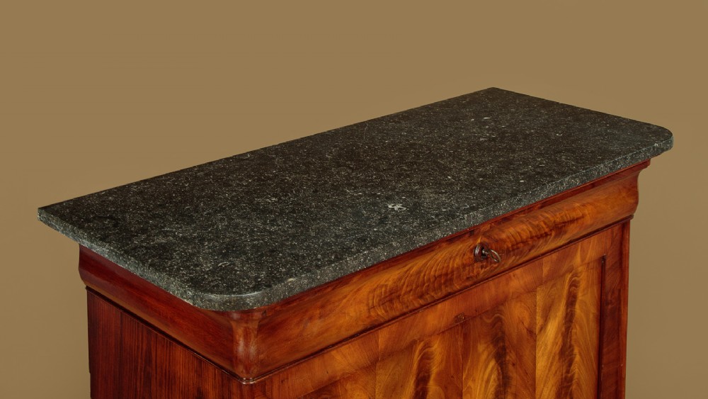 A 19th-century French Louis Philippe flame mahogany cabinet featuring a dark marble top, a frieze drawer, and four symmetrical veneered cupboard doors over a plinth base. View V