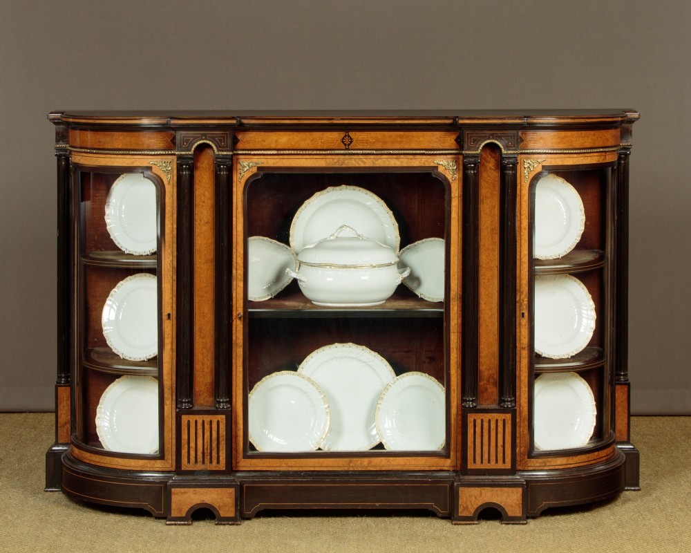 A late Victorian ebonised and burr walnut credenza featuring a central glazed door flanked by two curved side display glass doors with fluted column supports. View II