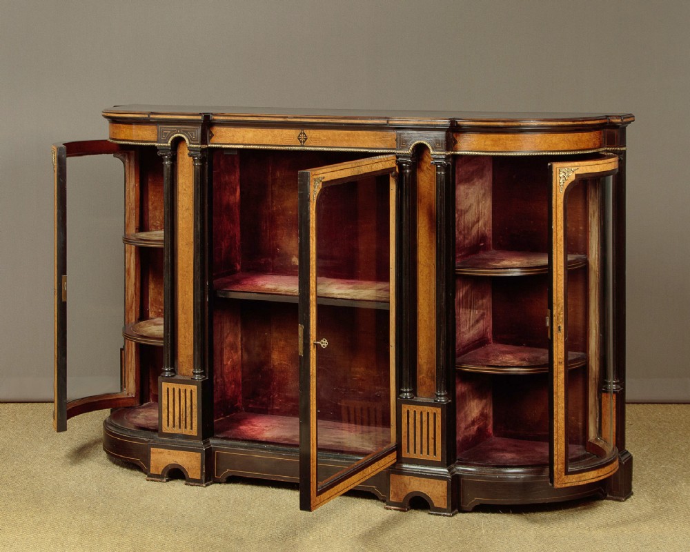 A late Victorian ebonised and burr walnut credenza featuring a central glazed door flanked by two curved side display glass doors with fluted column supports. View IV