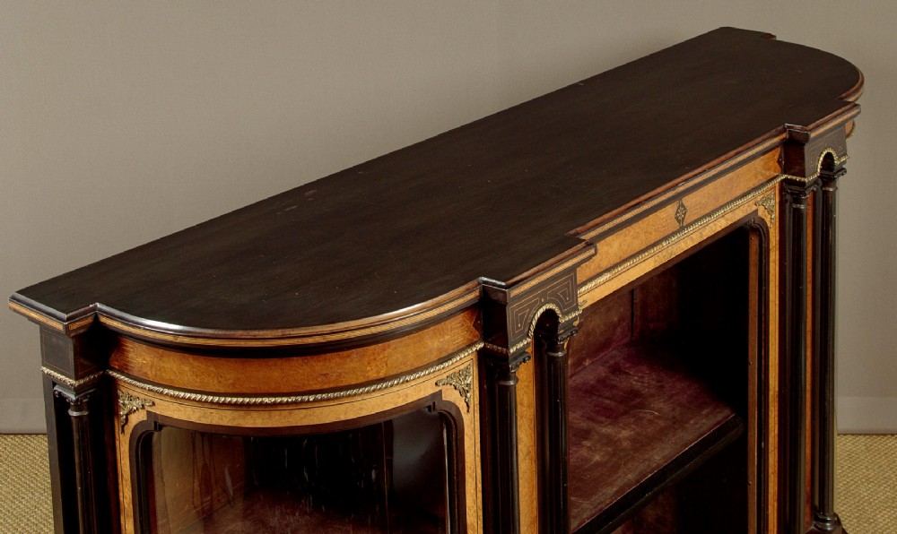 A late Victorian ebonised and burr walnut credenza featuring a central glazed door flanked by two curved side display glass doors with fluted column supports. View V