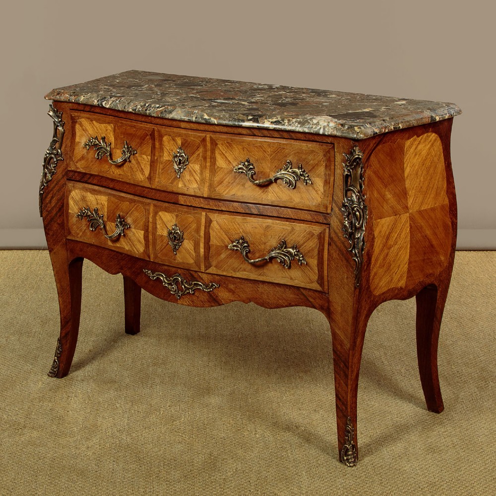 A 1930s Louis XV style bombe commode featuring a variegated grey marble top, parquetry wood veneer drawers, and ornate brass mounts. View III