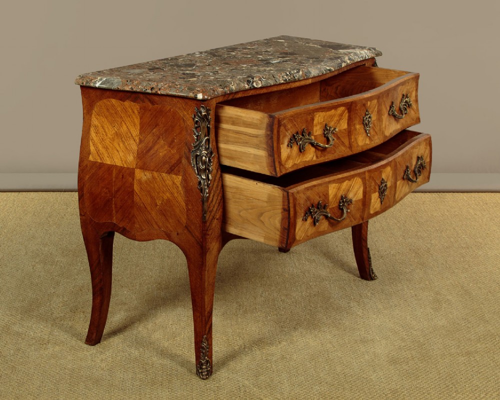 A 1930s Louis XV style bombe commode featuring a variegated grey marble top, parquetry wood veneer drawers, and ornate brass mounts. View IV