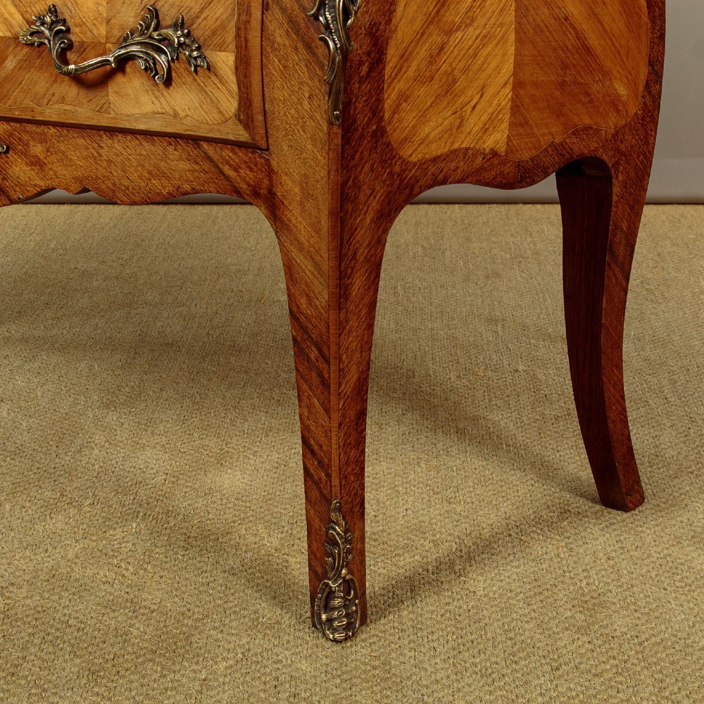 A 1930s Louis XV style bombe commode featuring a variegated grey marble top, parquetry wood veneer drawers, and ornate brass mounts. View XII