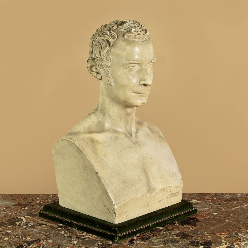 An off-white mid-nineteenth-century plaster bust depicting a gentleman with short wavy hair and bare shoulders. View III
