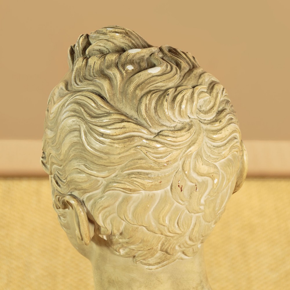 An off-white mid-nineteenth-century plaster bust depicting a gentleman with short wavy hair and bare shoulders. View VIII