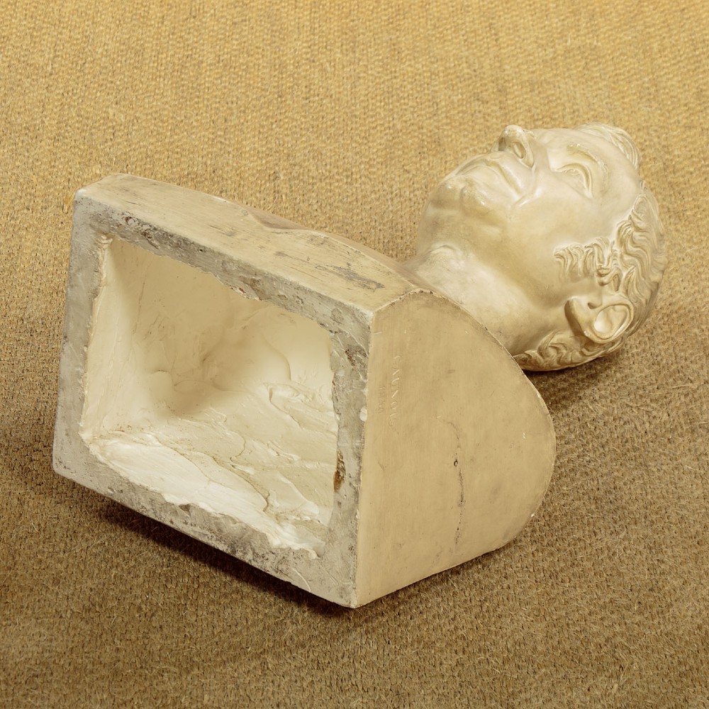 An off-white mid-nineteenth-century plaster bust depicting a gentleman with short wavy hair and bare shoulders. View XII