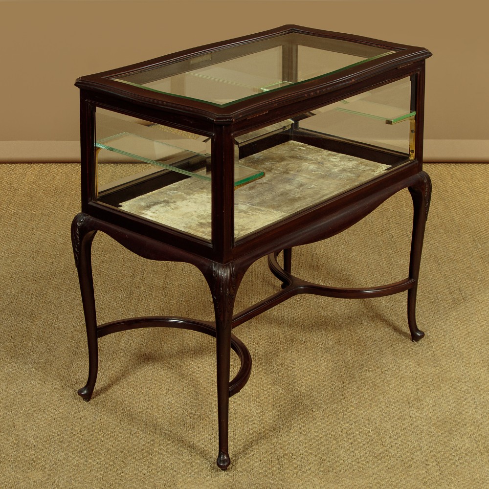 A dark mahogany glass-enclosed bijouterie display table featuring cabriole legs, curved stretchers, glazed side panels, and internal glass shelves. View III