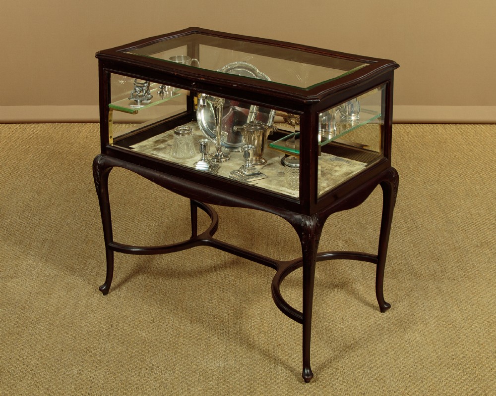 A dark mahogany glass-enclosed bijouterie display table featuring cabriole legs, curved stretchers, glazed side panels, and internal glass shelves. View IV