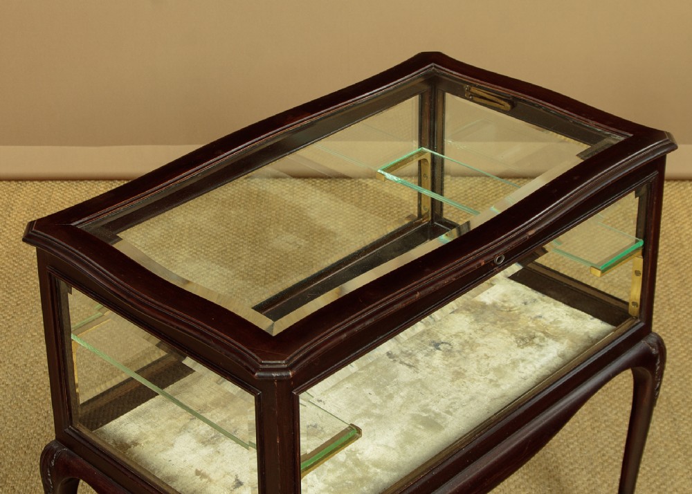 A dark mahogany glass-enclosed bijouterie display table featuring cabriole legs, curved stretchers, glazed side panels, and internal glass shelves. View VI