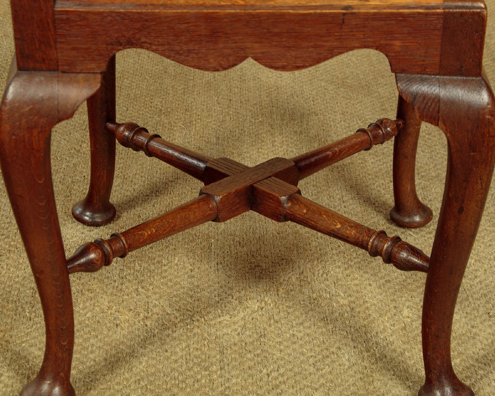 A pair of dark oak corner armchairs featuring pierced heart splats, cabriole legs, turned stretchers, and black upholstered seat cushions. View VII