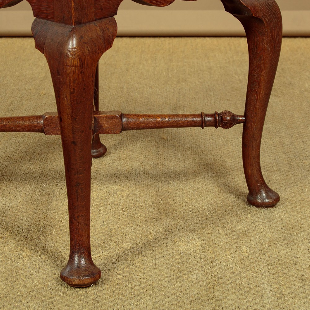 A pair of dark oak corner armchairs featuring pierced heart splats, cabriole legs, turned stretchers, and black upholstered seat cushions. View VIII