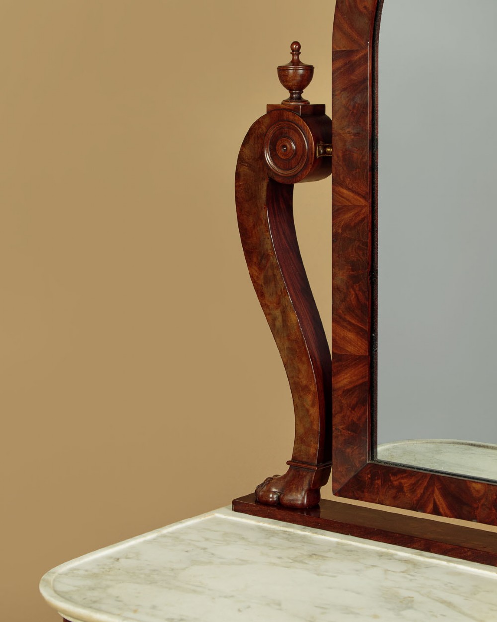 A mid-19th-century mahogany dressing table featuring a white marble surface, arched swing mirror on carved scroll supports, and lower plinth base. View V
